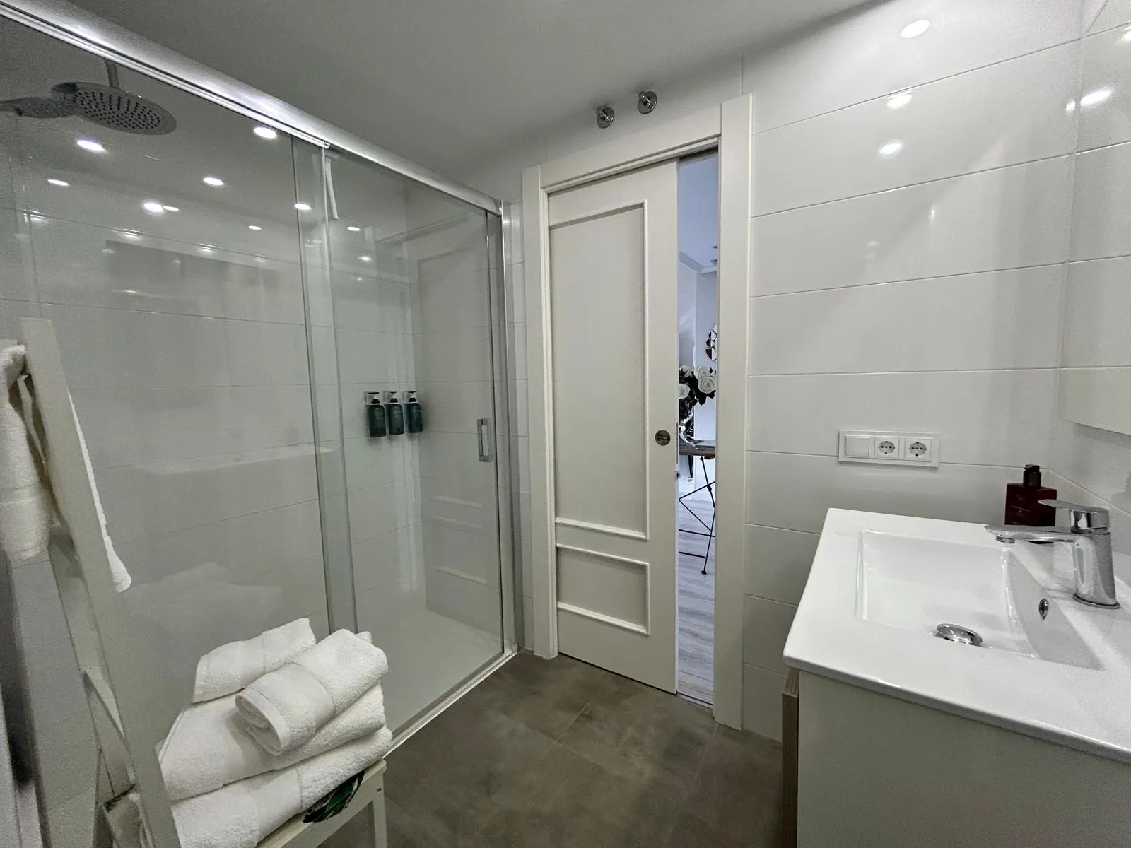 Bathroom with walk-in shower, basin and towels