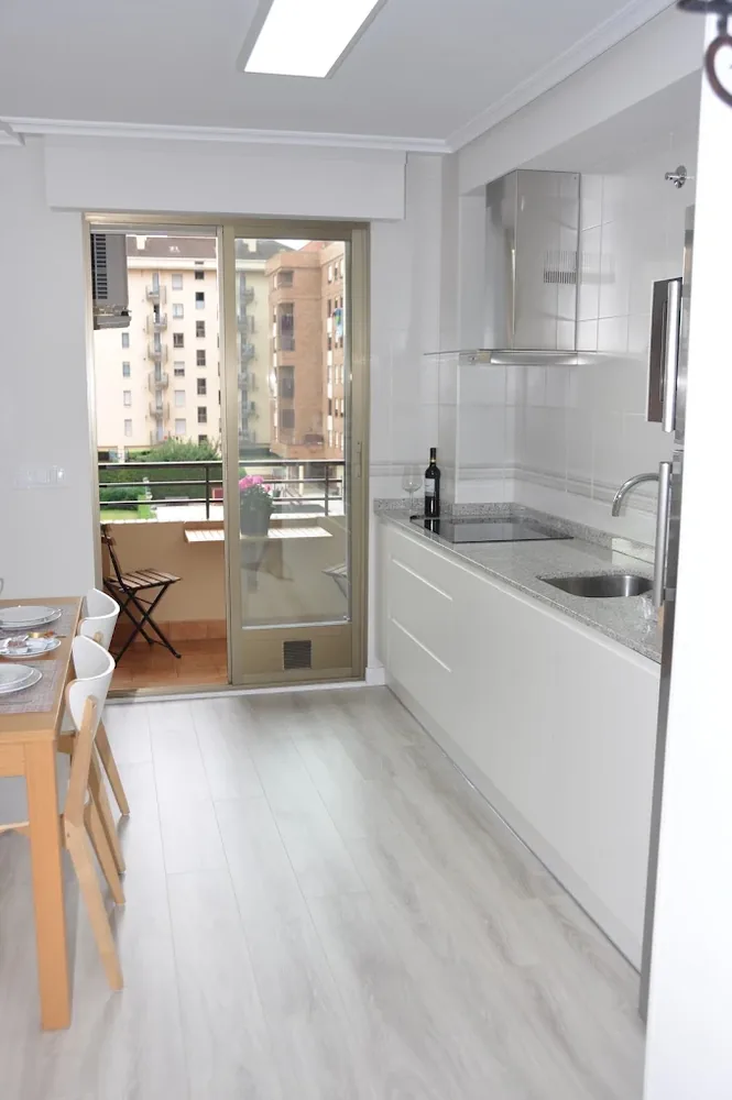 White fitted kitchen opening onto the terrace