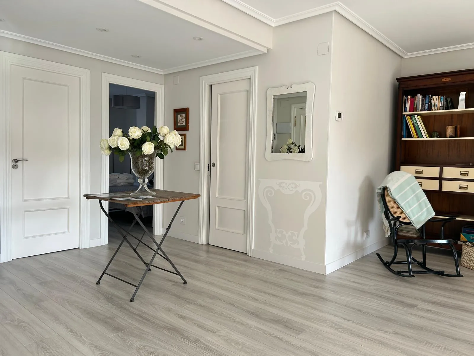 Entrance hall with side table, flowers and rocking chair