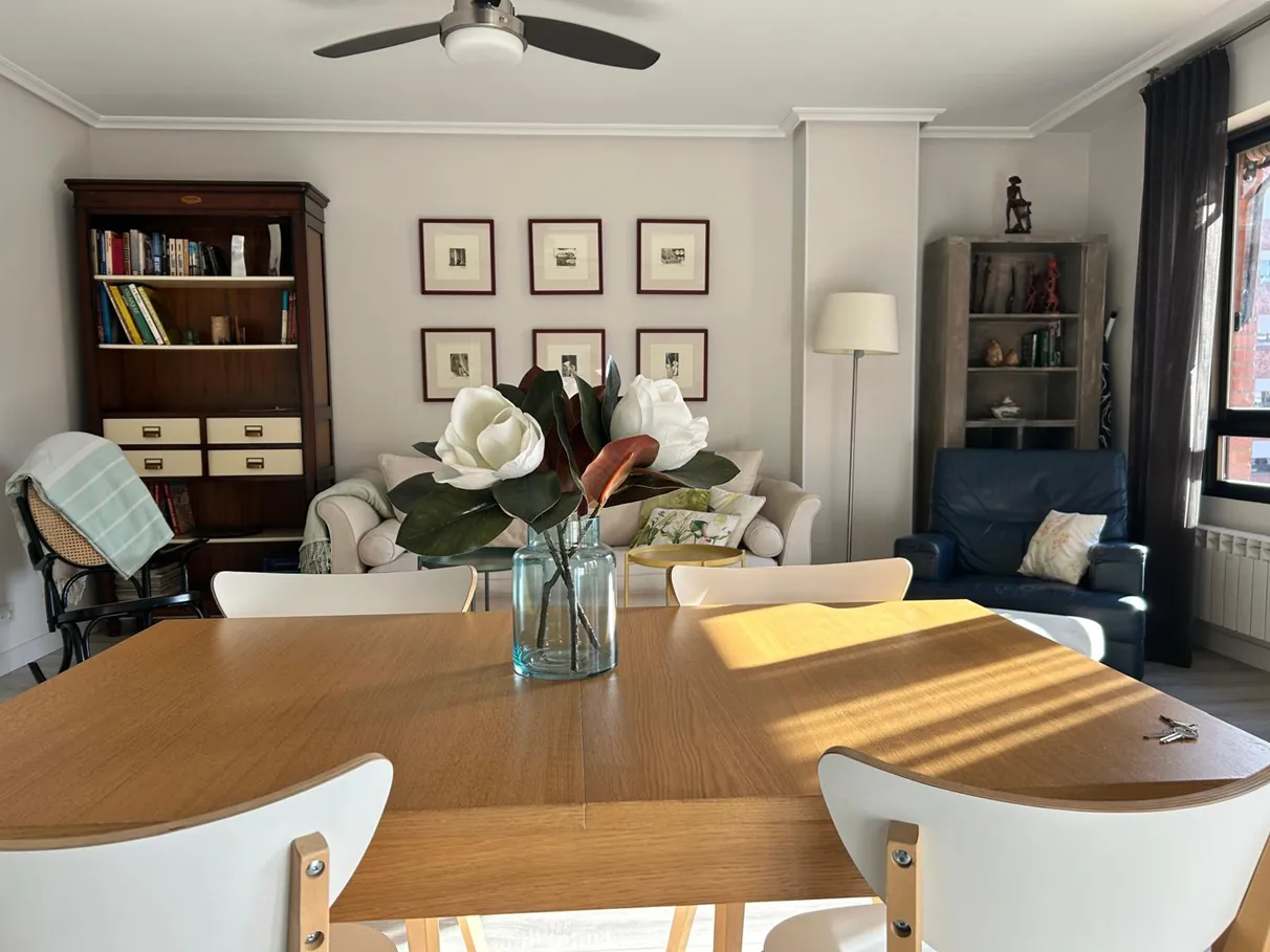 Dining table with flowers and the living room behind