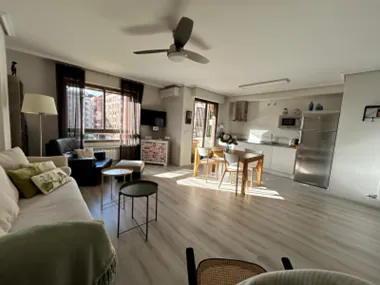 Living room open to the kitchen, with dining table