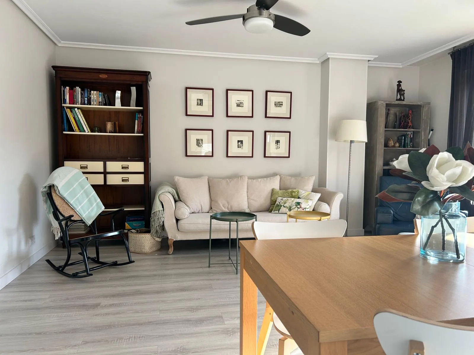 Living room with bookcase, sofa and dining table