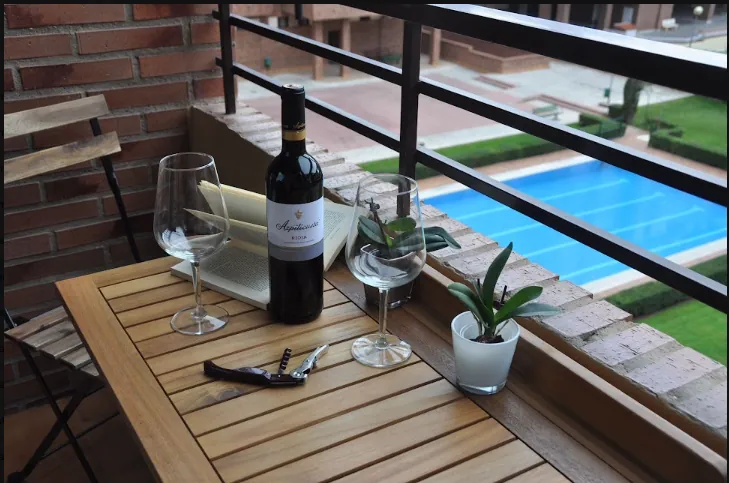Terrace with table, glasses and Rioja wine overlooking the pool